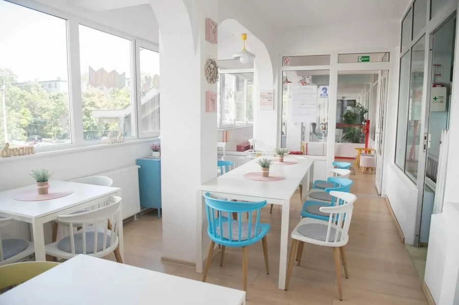 Mese și scaune lângă ferestre la Kids Joy Center